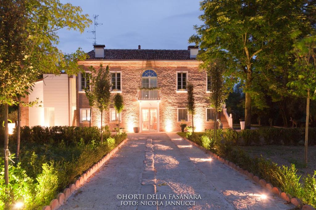 a stone house with lights on a driveway at Horti Della Fasanara in Ferrara