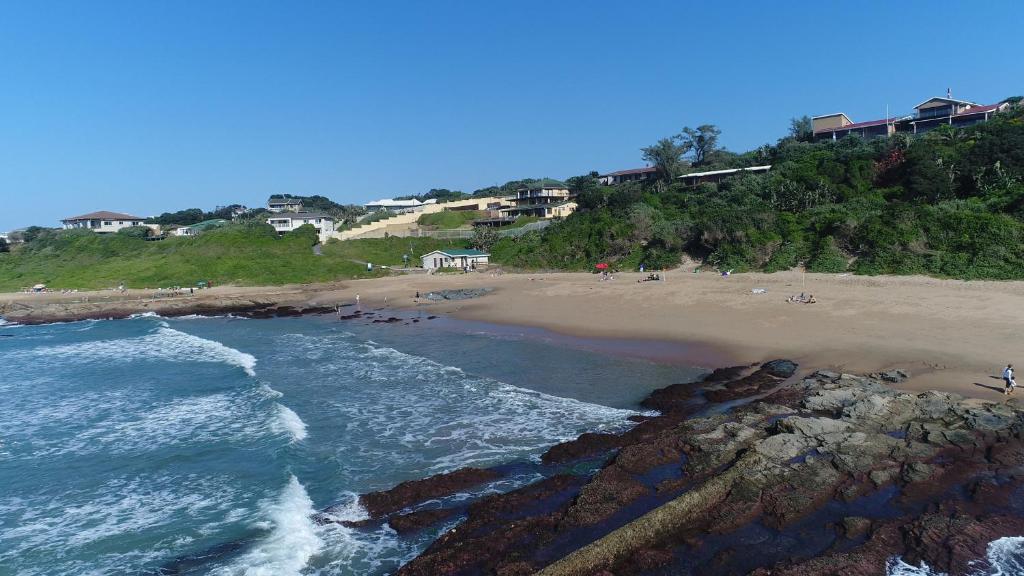 an aerial view of a beach with people on it at Summer Place Umzumbe in Umzumbe