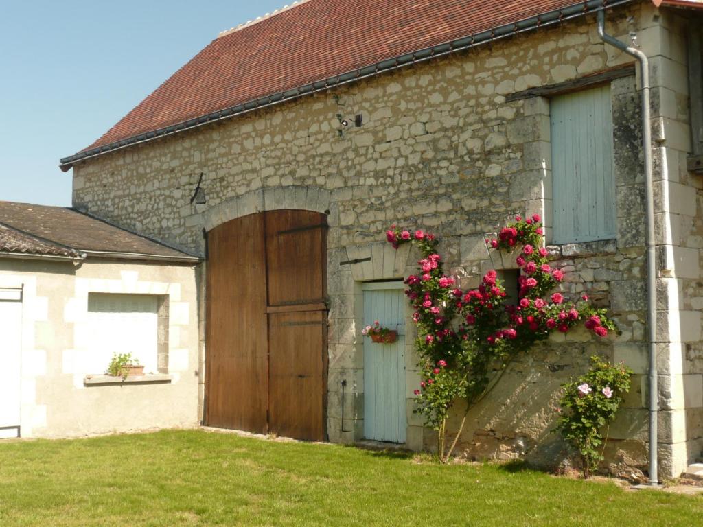 a brick building with a door and flowers on it at Aux Jardin&#39;s de la Bosniere in Cussay