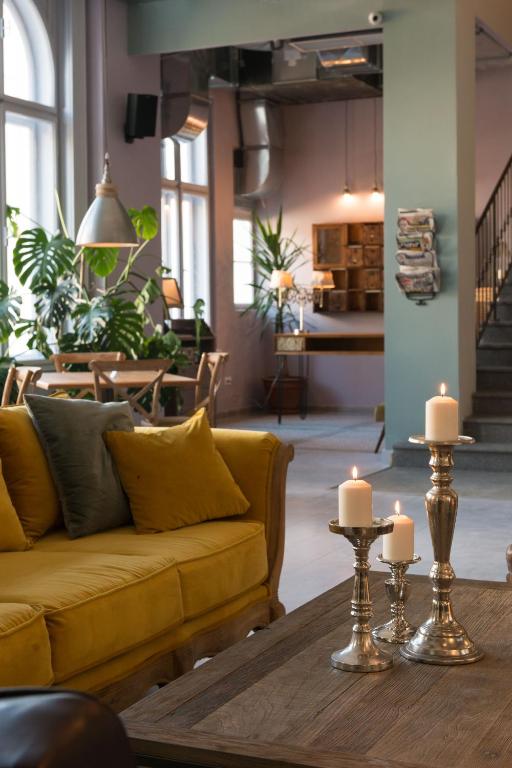 a living room with a yellow couch and candles on a table at Smokvica Dorćol B&B in Belgrade