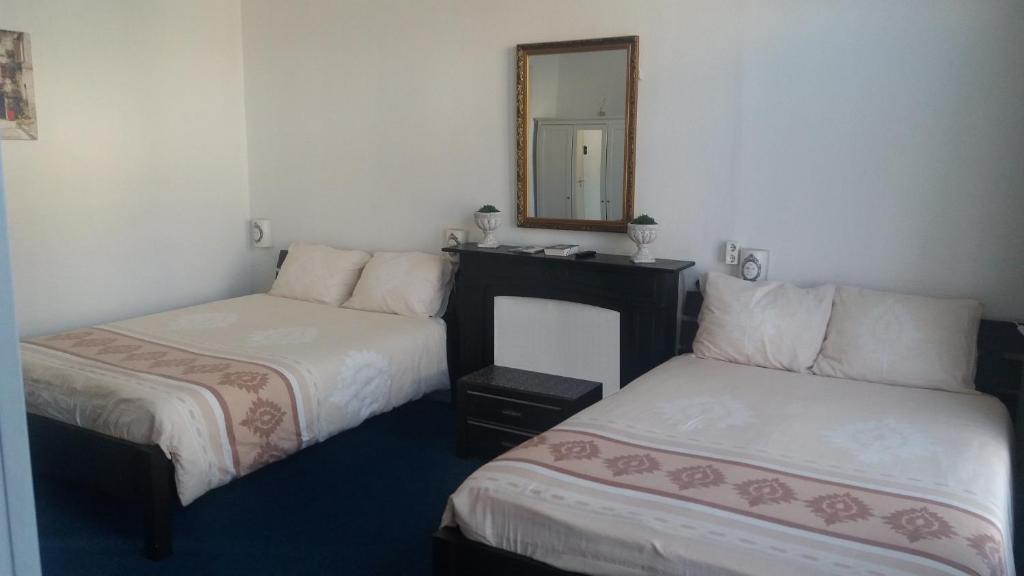 um quarto de hotel com duas camas e um espelho em All-In Hotel em Den Bosch