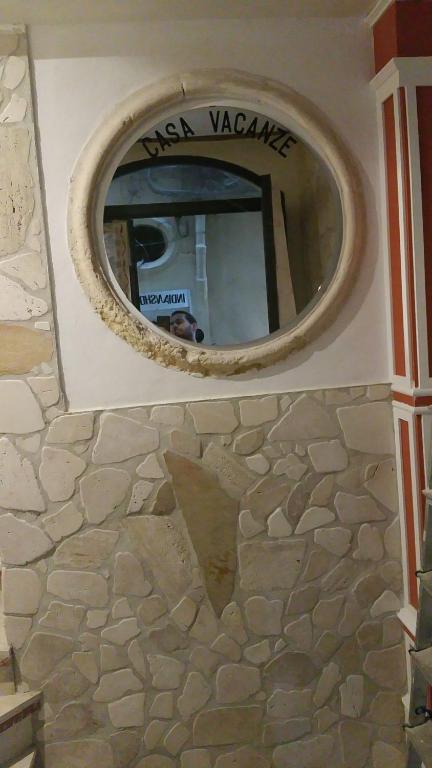 シラクーサにあるCasa vacanze Simopieroの石造りの壁面の円鏡