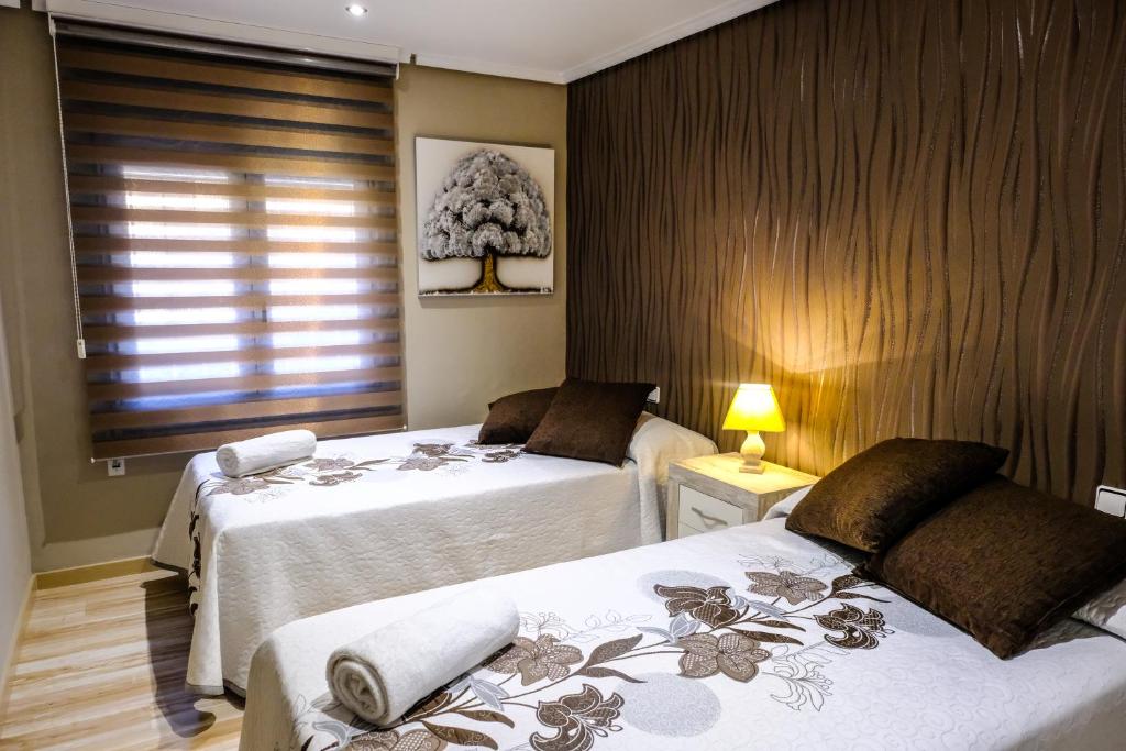 1 dormitorio con 2 camas y ventana en Mequedo San Pascual, en Alcañiz