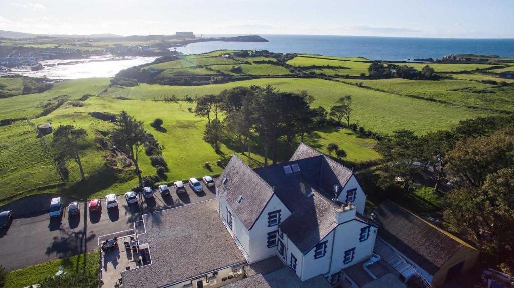 an aerial view of a large house with the ocean at Gwesty Gadlys Hotel in Cemaes Bay