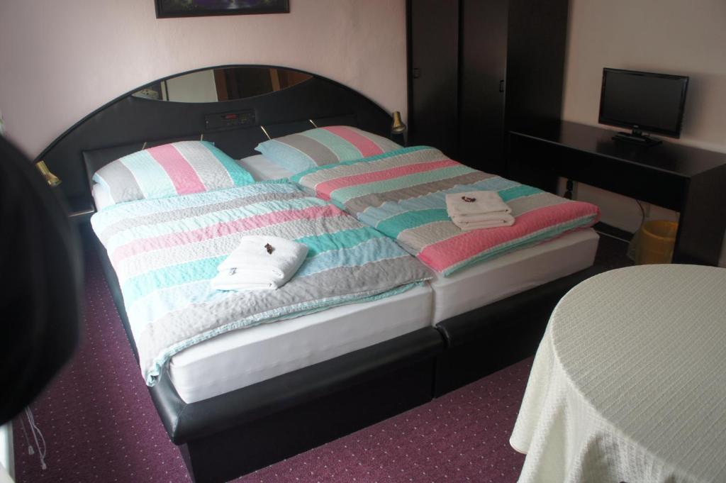 a bed with striped blankets and towels on it at Corso in Bad Wilsnack