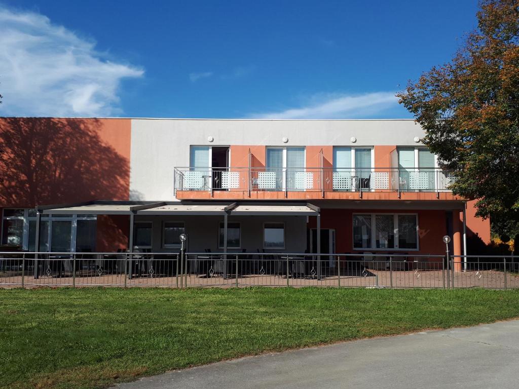 a building with a fence in front of it at Penzion Letališče in Murska Sobota