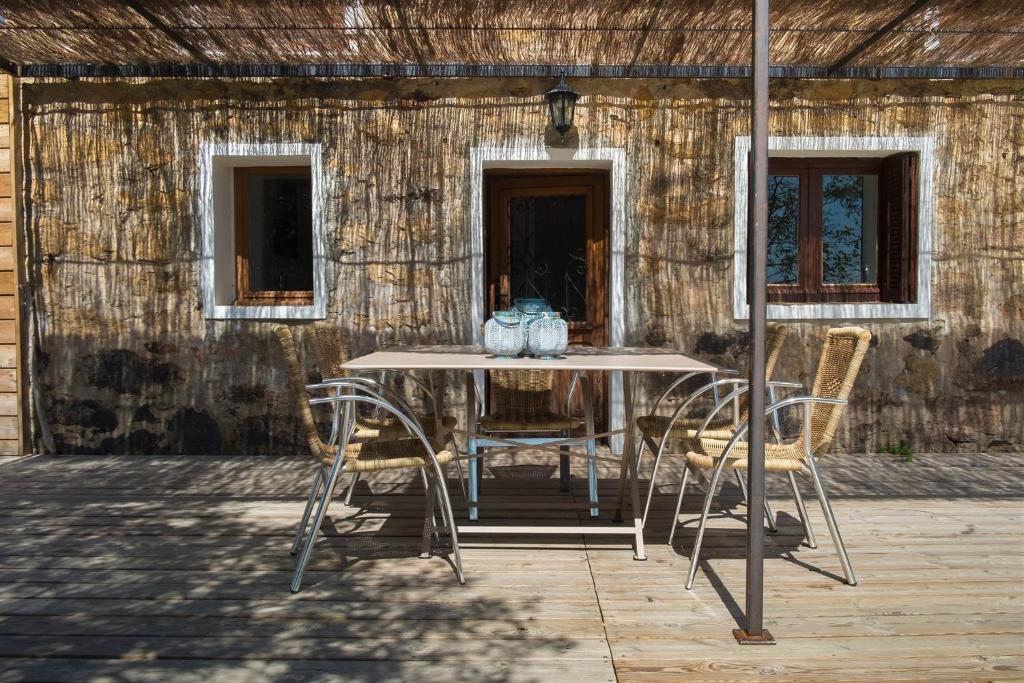 ポルト・ヴェッキオにあるA Casuchjaの木造建築の前のテーブルと椅子