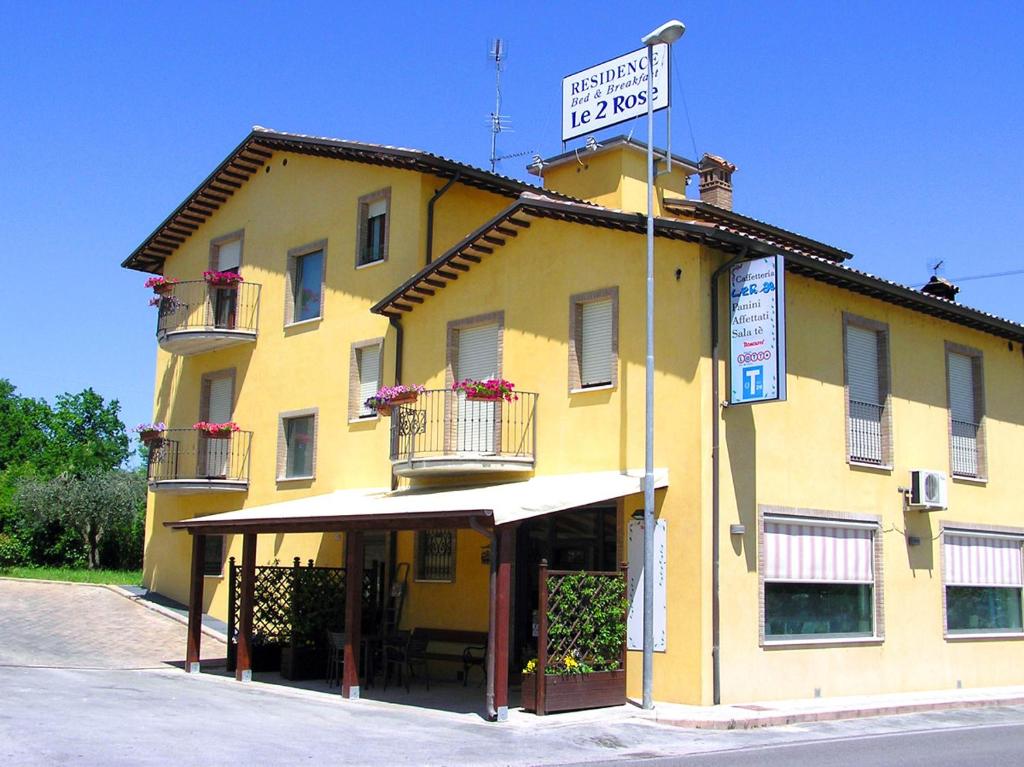 un edificio amarillo con un cartel encima en Albergo Le 2 Rose, en San Severino Marche