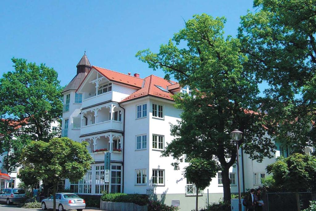 un grande edificio bianco con tetto rosso di Wohnpark Granitz by Rujana a Binz