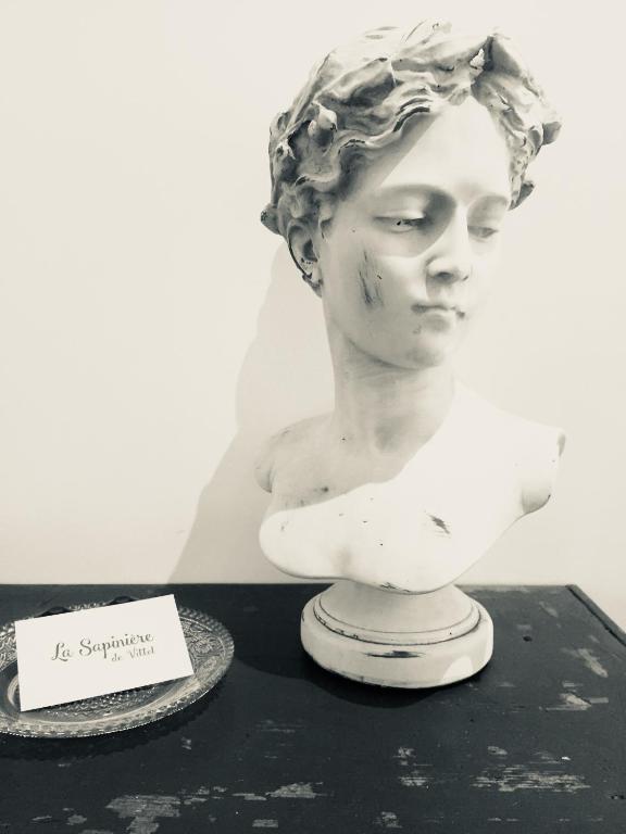 un busto de una mujer en una mesa con una nota en La Sapinière de Vittel, en Vittel