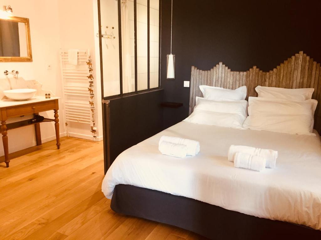 a bedroom with a large bed with two towels on it at La Sapinière de Vittel in Vittel