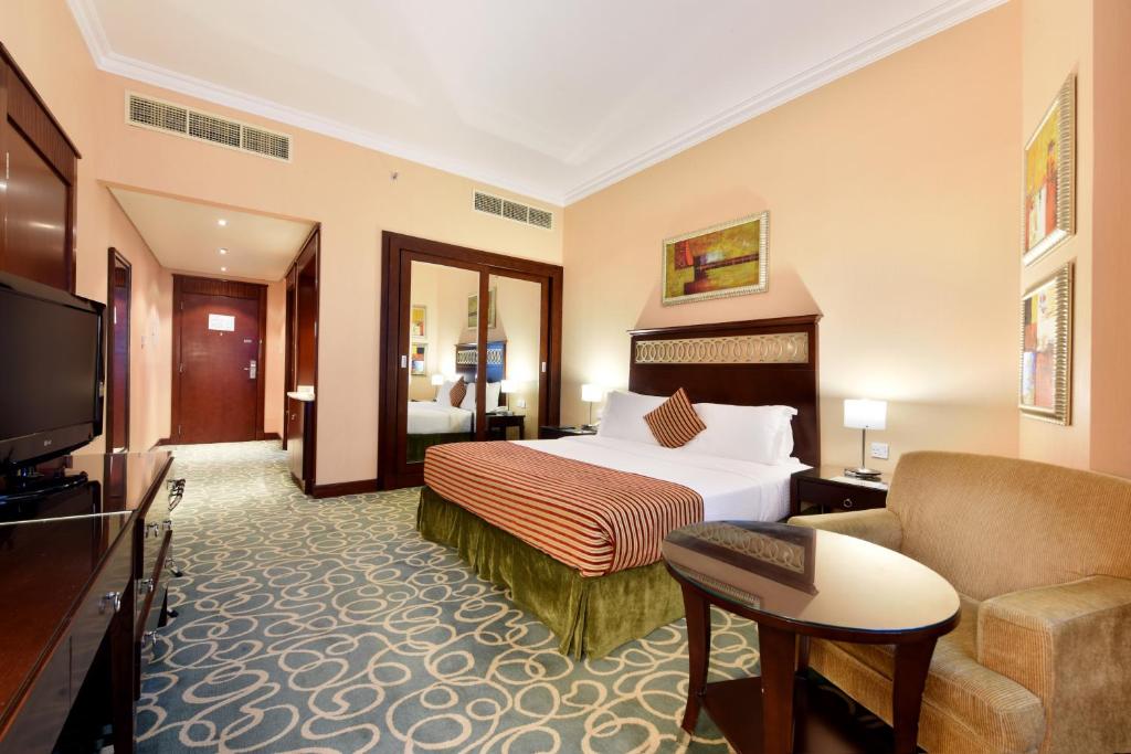 a hotel room with a bed and a couch at Concorde Hotel Fujairah in Fujairah