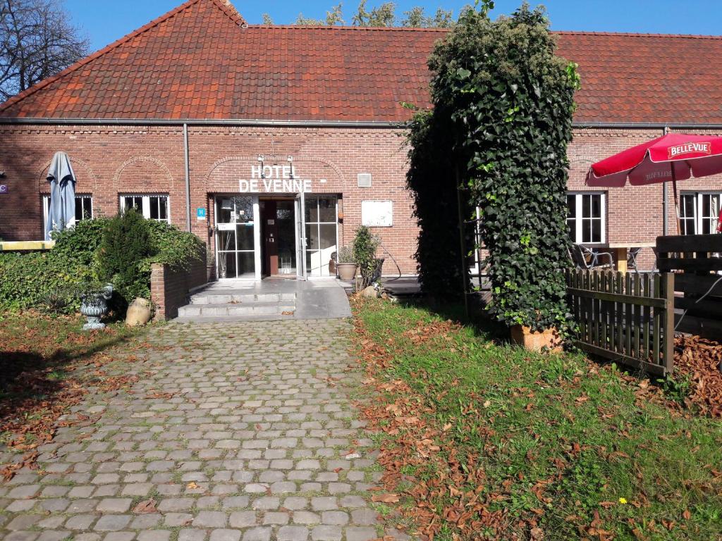 een bakstenen gebouw met een bord dat niet de toekomst leest bij Hotel De Venne in Genk