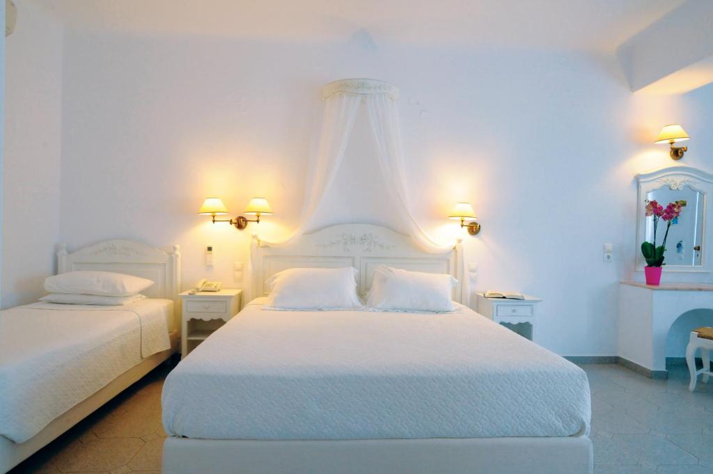 Postel nebo postele na pokoji v ubytování Kamari Hotel