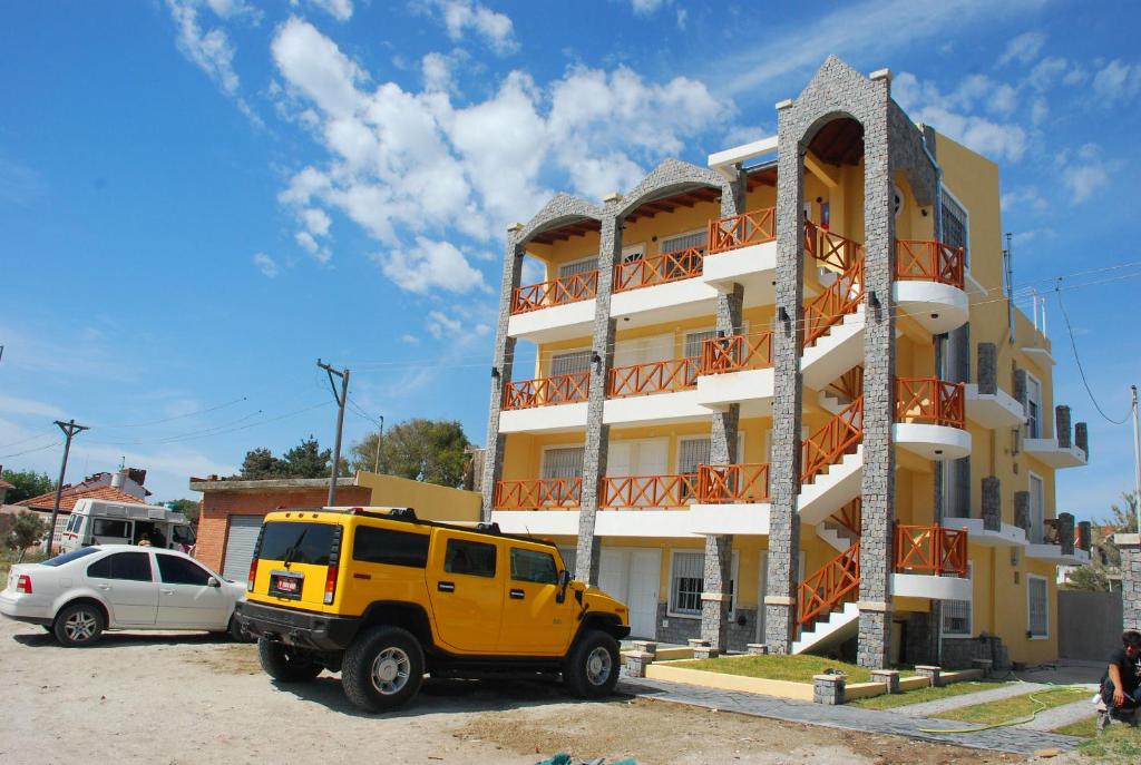 une jeep jaune garée devant un bâtiment dans l'établissement Complejo Berilde II, à San Clemente del Tuyú