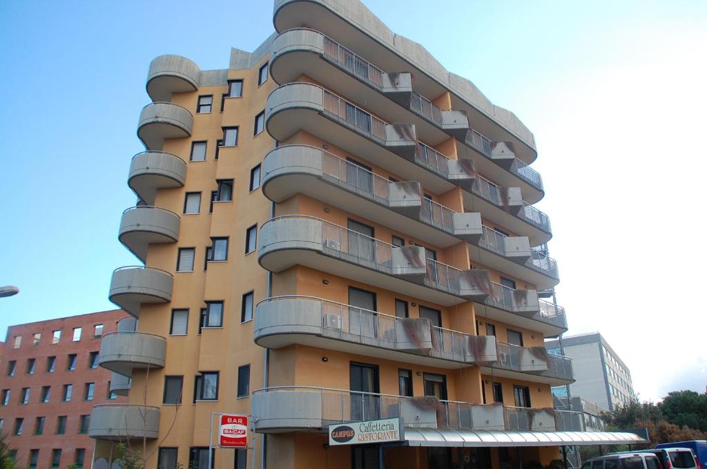 un edificio alto con balcones a un lado. en Campus Hotel, en Bari