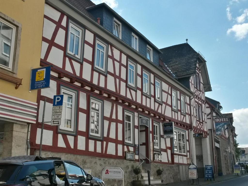 abered building with a red and white building at Hotel Holländischer Hof in Lich