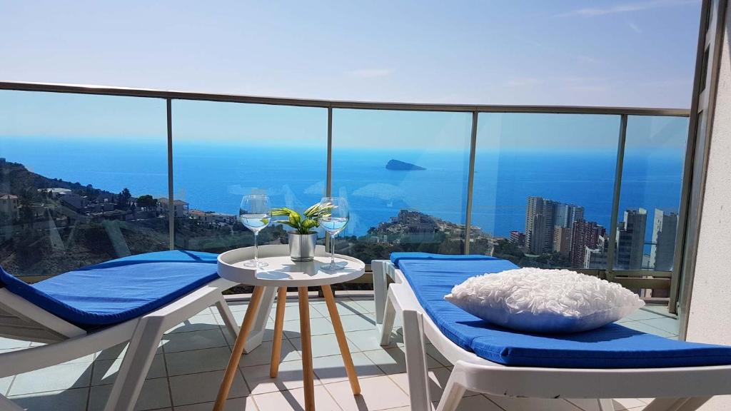 balcón con mesa, sillas y vistas a la ciudad en Highrise apartment with private terrace & sea views - 34th floor, en Benidorm