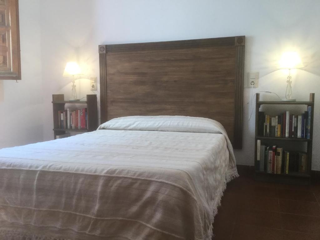 a bedroom with a large bed with a large headboard at La Ermita del Poqueira in Bubión