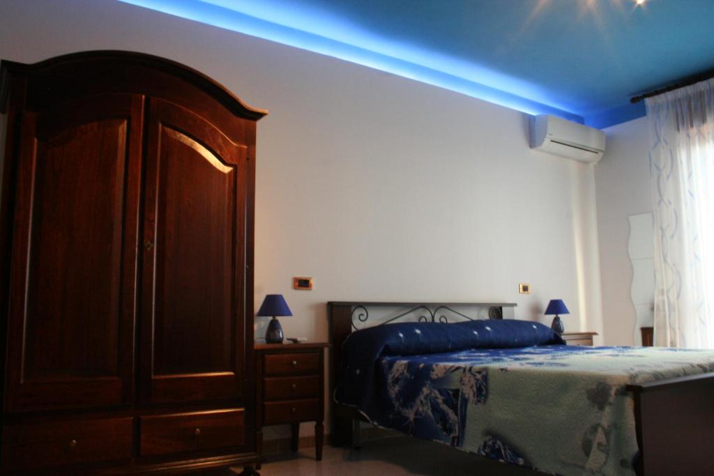 ein Schlafzimmer mit einem Bett und einem blauen Licht in der Unterkunft Costa d'Amalfi e Cilento in Pontecagnano