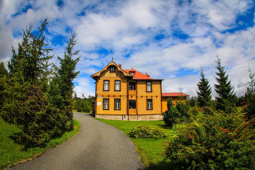 a large yellow house on the side of a road at SŠvP 1. máj in Tatranská Lomnica