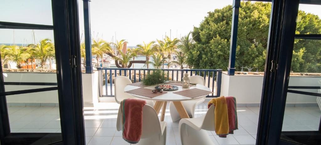 una mesa y sillas en un balcón con palmeras en VistAgua, en Puerto Calero