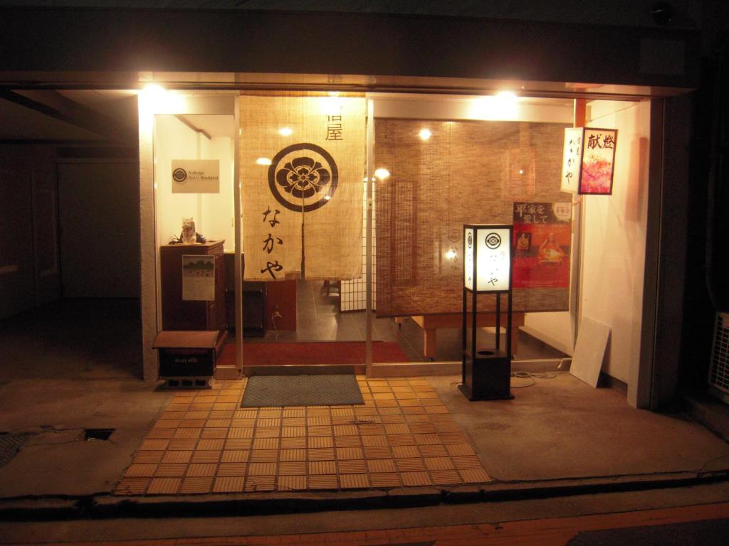 a store front at night with a sign on the wall at Nakaya House in Miyajima