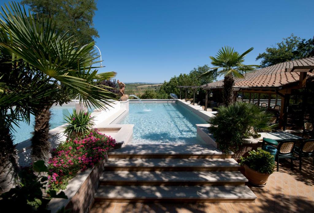 una piscina con escaleras que conducen a un complejo en Hotel Il Pietreto en Colle Val D'Elsa