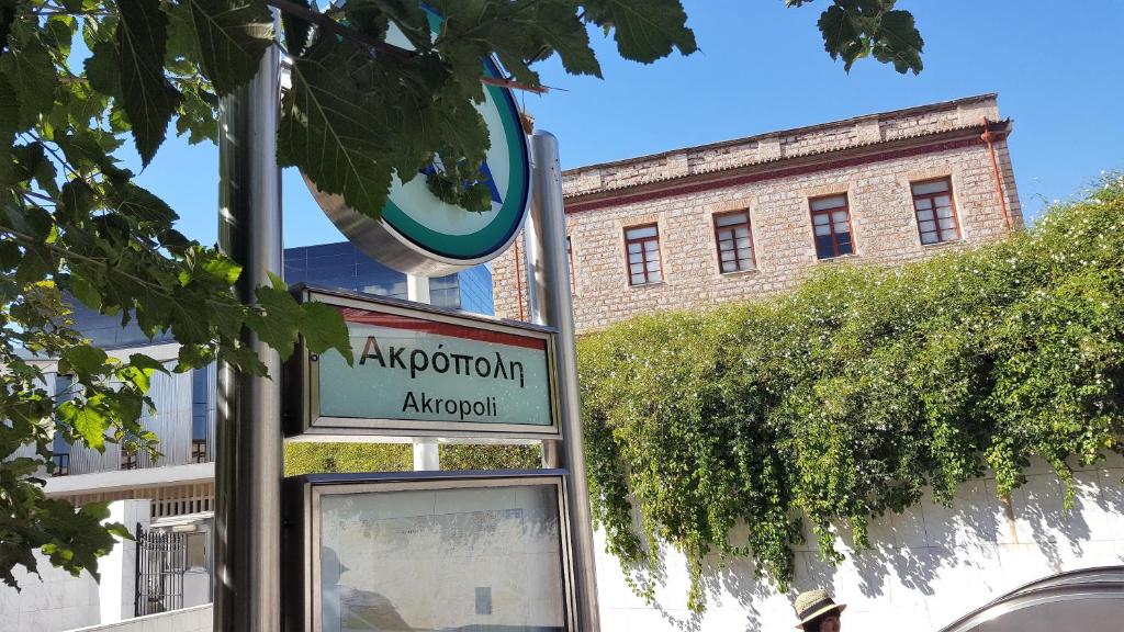 un letrero de la calle frente a un edificio de ladrillo en Acropolis Heart, en Atenas