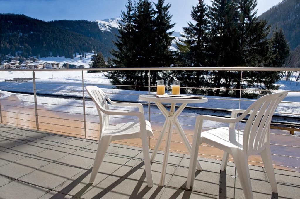 a white table and two chairs on a balcony at Studio 54 in Davos