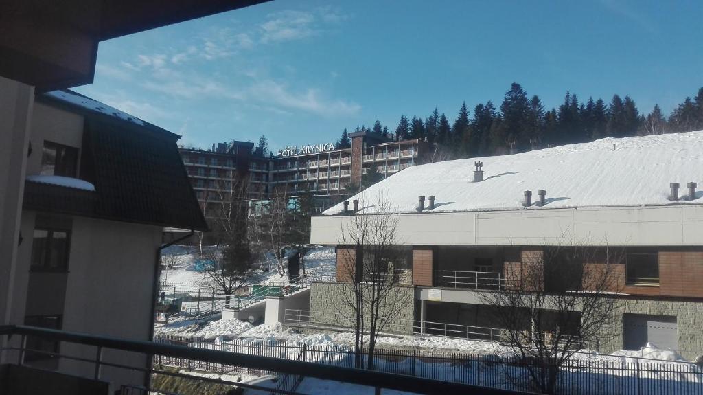 a view of a building with a snow covered roof at Apartament przy Stoku in Krynica Zdrój