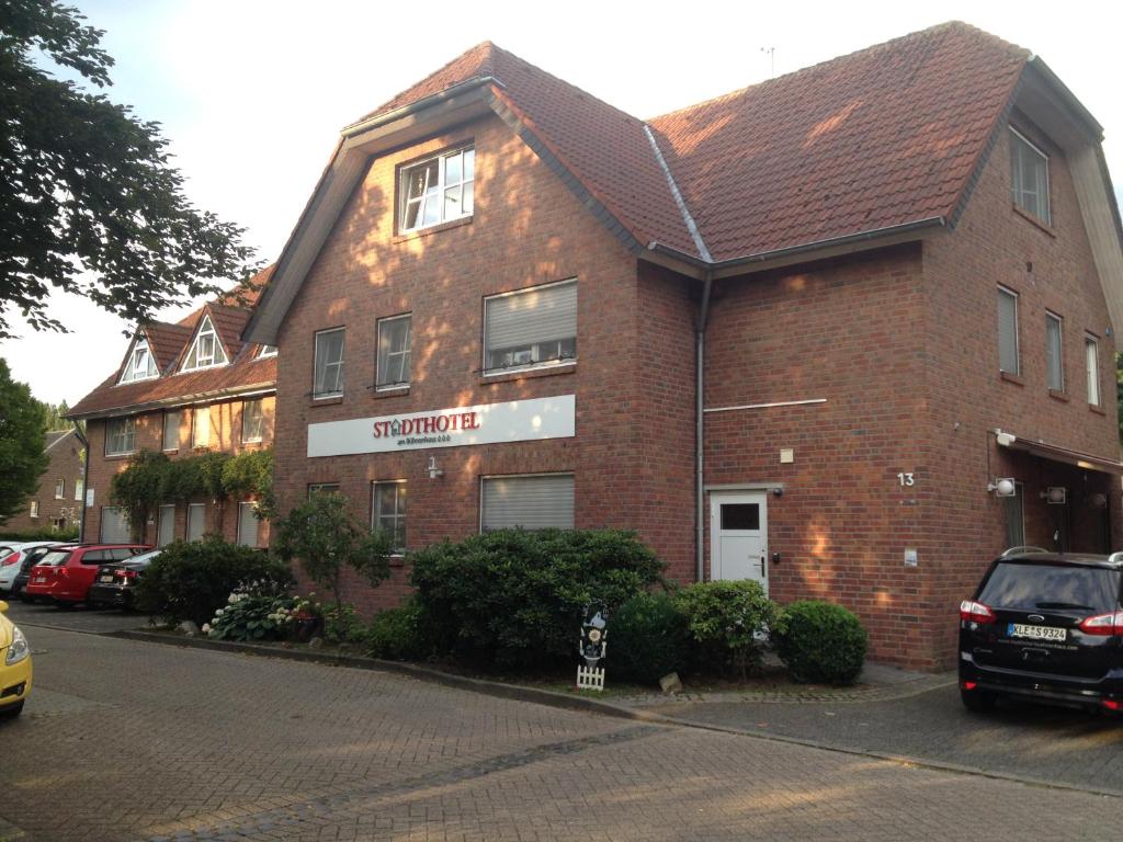 a brick building with cars parked in front of it at Stadthotel am Bühnenhaus in Kevelaer