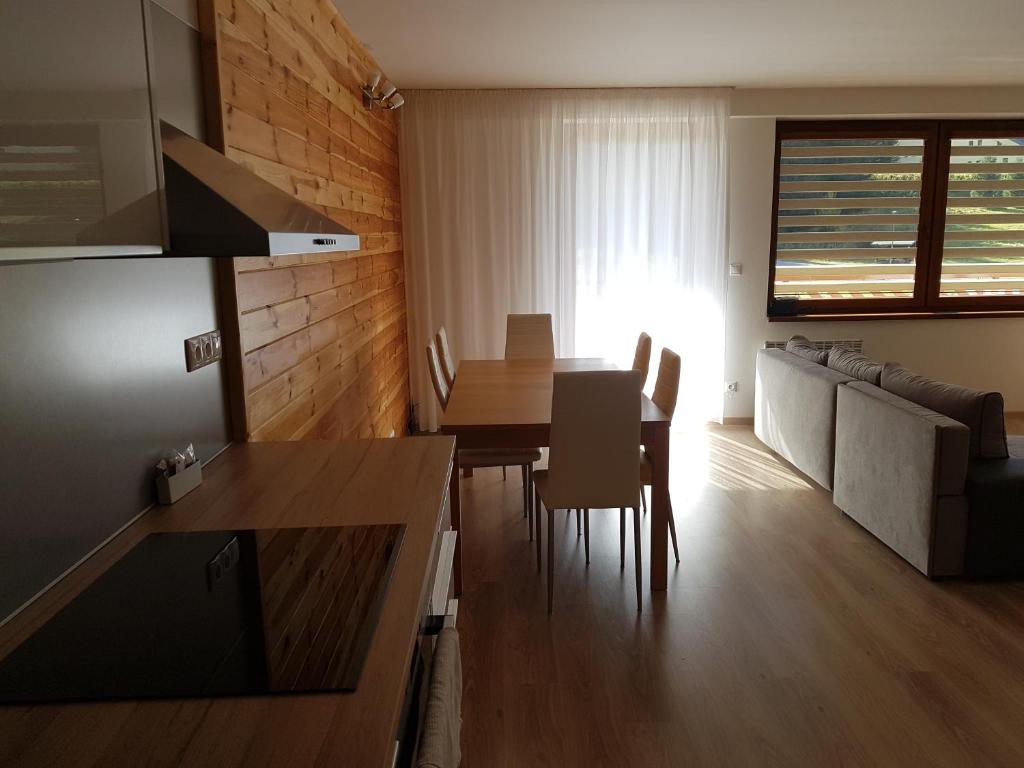a kitchen and living room with a table and chairs at Apartman-Bruno in Donovaly