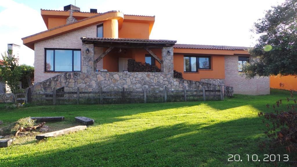 a house with a stone fence in front of a yard at Casa Vargas in Pedrezuela