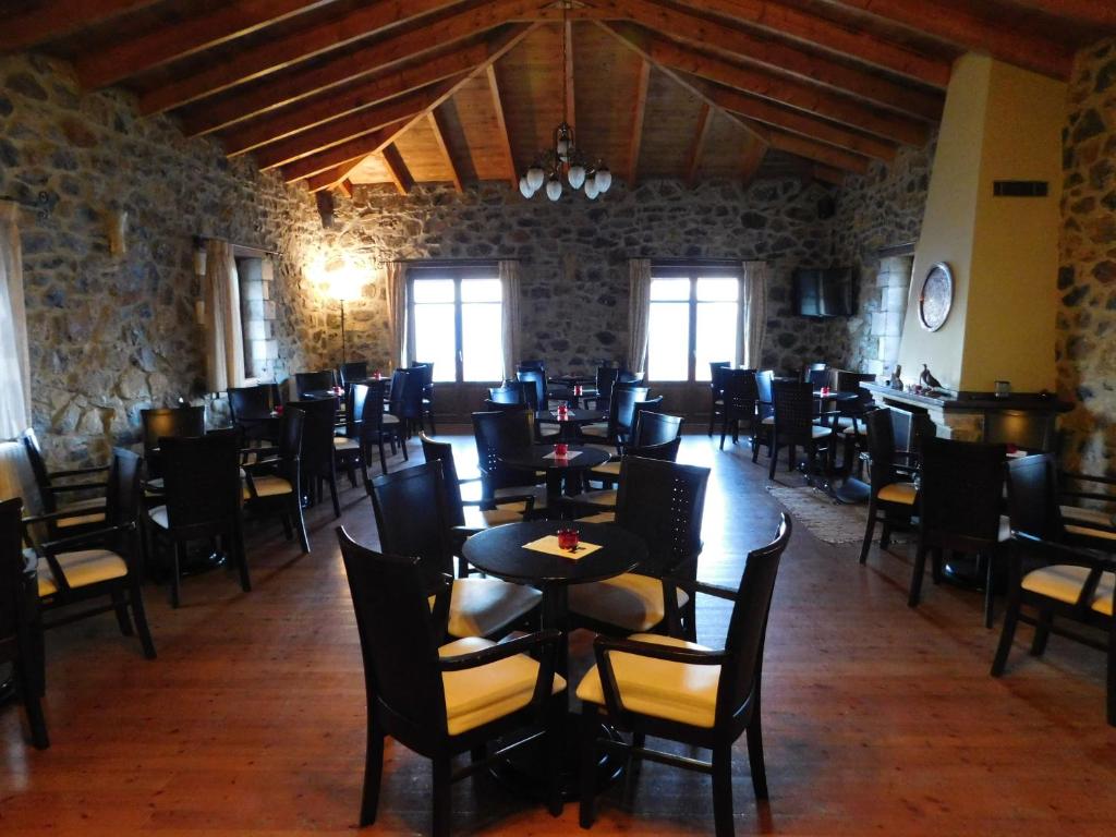 a dining room with tables and chairs in a building at Akrothea Hotel in Goura