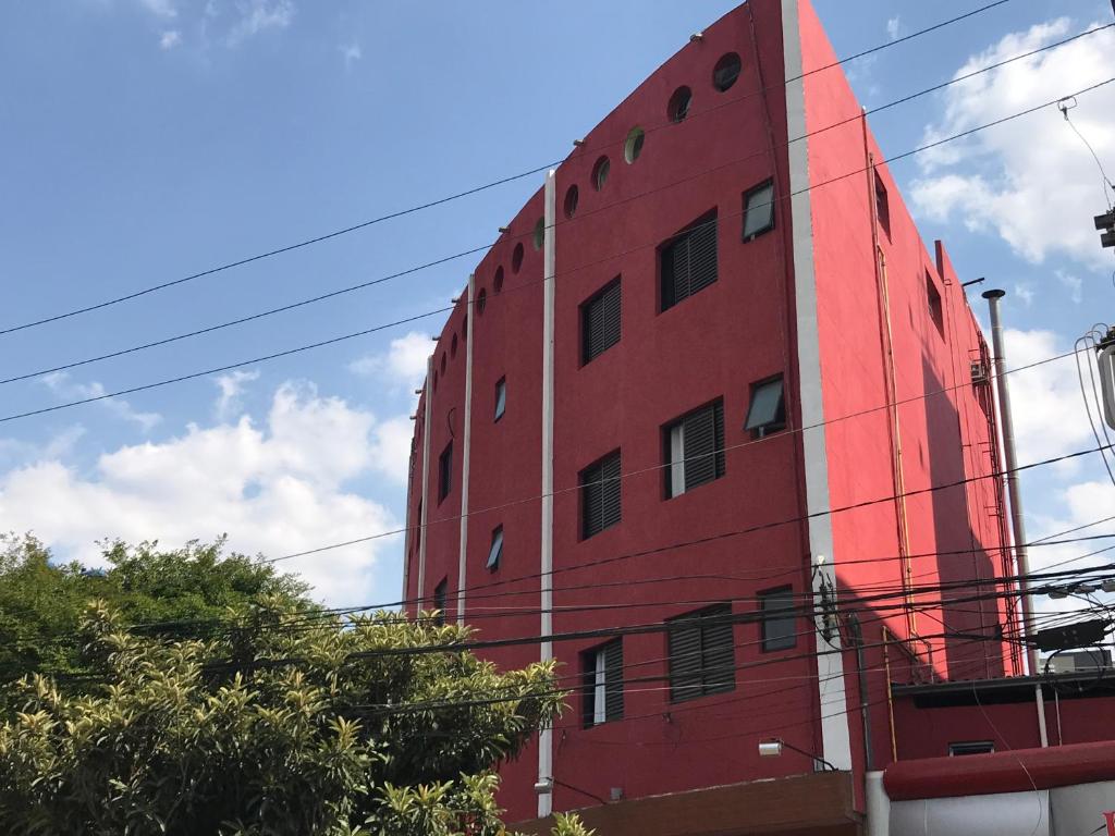 een rood gebouw met ramen aan de zijkant bij HOTEL FLOR DO AMAZONAS (ADULTS ONLY) in São Caetano do Sul