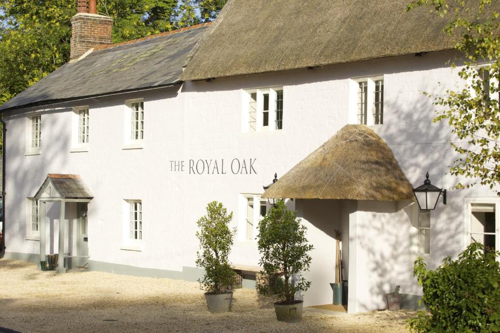 un edificio blanco con techo de paja en The Royal Oak en Anstey