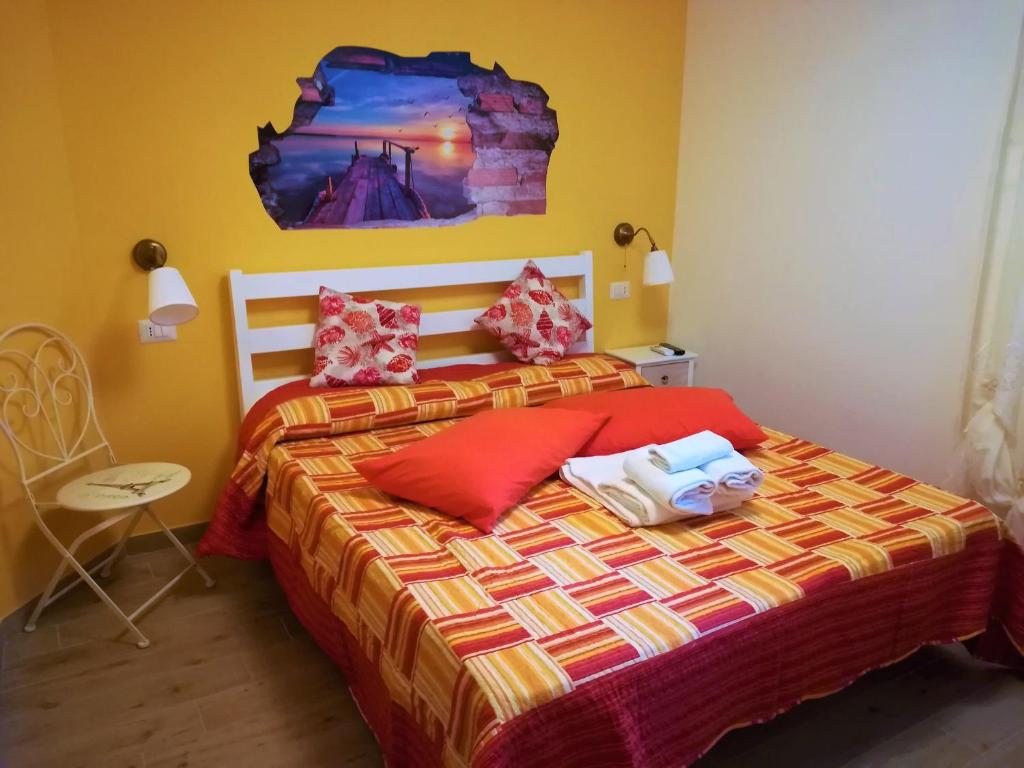 a bedroom with a bed with red pillows at B&B Villa Jasiga in Fregene