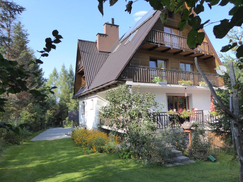 een huis met een balkon en een tuin bij Noclegi pod Jaworzyną II in Koninki