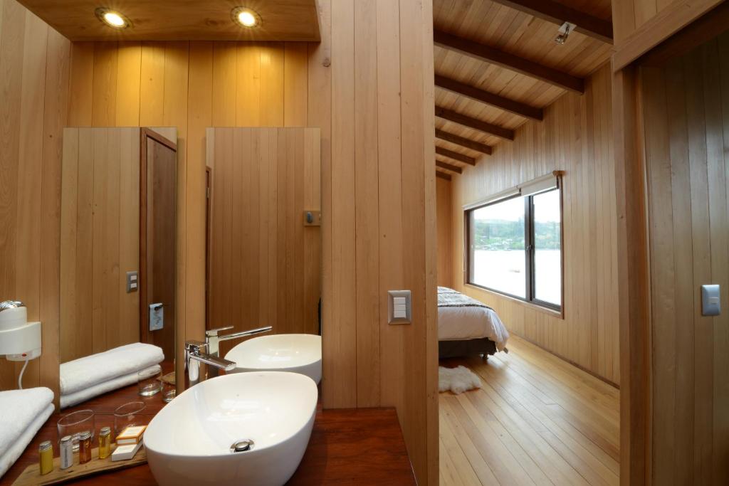 Un baño con lavabo, inodoro y una cama. en Sizigia, en Castro