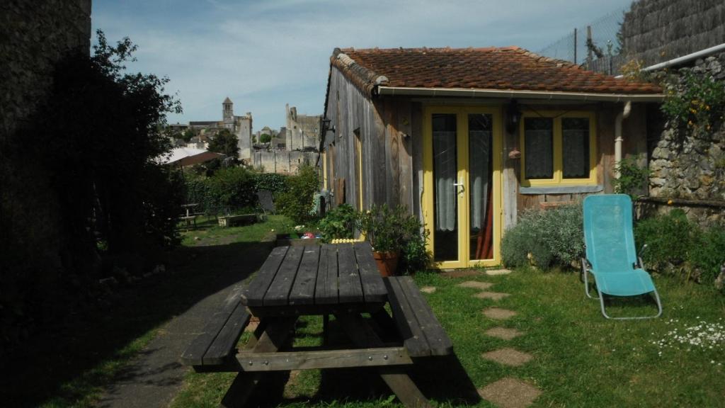 a picnic table and a blue chair in front of a house at La Maison Rouge in Chauvigny