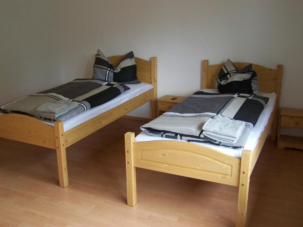 2 Holzbetten nebeneinander in einem Zimmer in der Unterkunft Hostel Wendt in Fintel