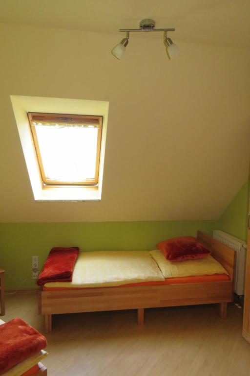 a small bedroom with a bed with a window at Stollenklause in Hormersdorf