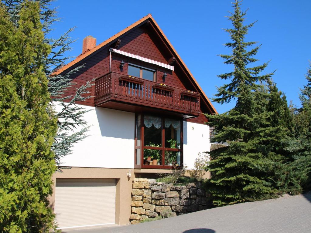 a house with a balcony and a garage at Ferienwohnung Rennsteigblick in Riechheim