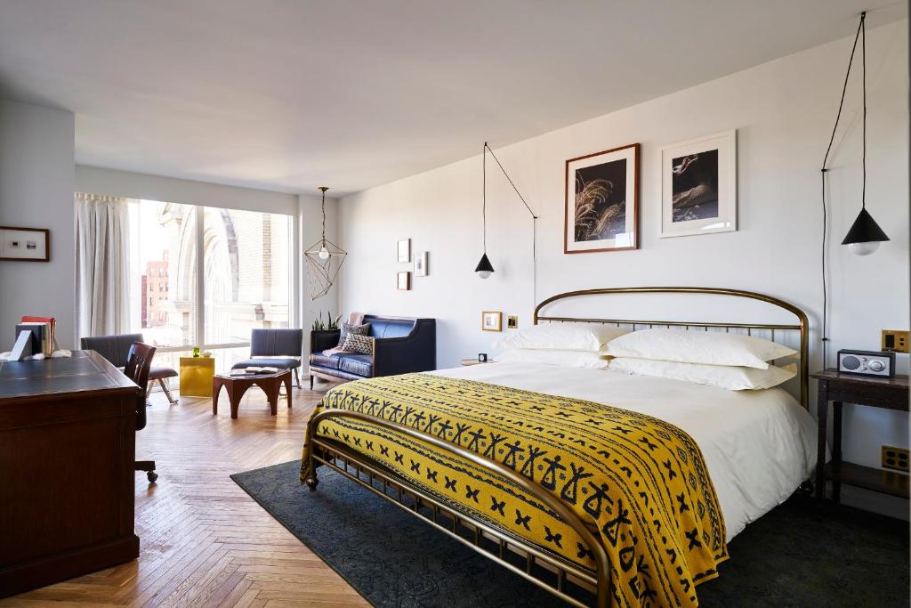 a bedroom with a large bed with a yellow blanket at The LINE Hotel DC in Washington