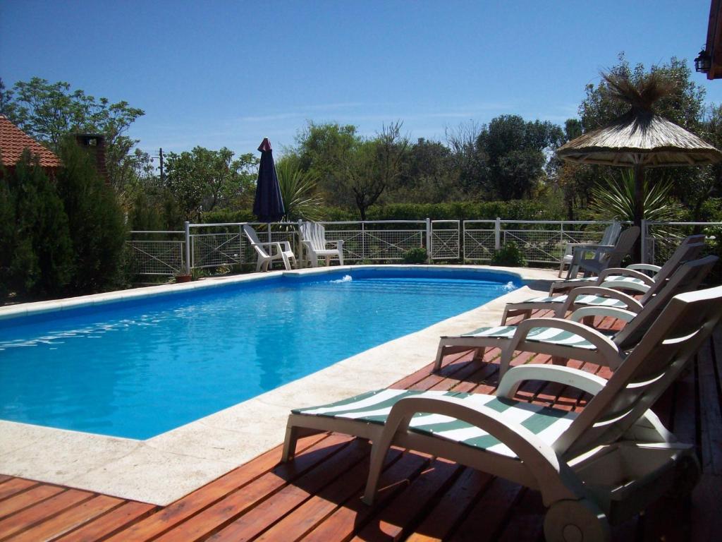 a swimming pool with lounge chairs and an umbrella at Complejo Sagrado Corazón in Merlo