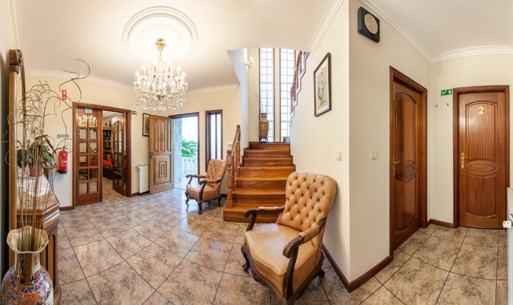 een woonkamer met een trap en een kroonluchter bij Casa da Quinta Nova in Valença