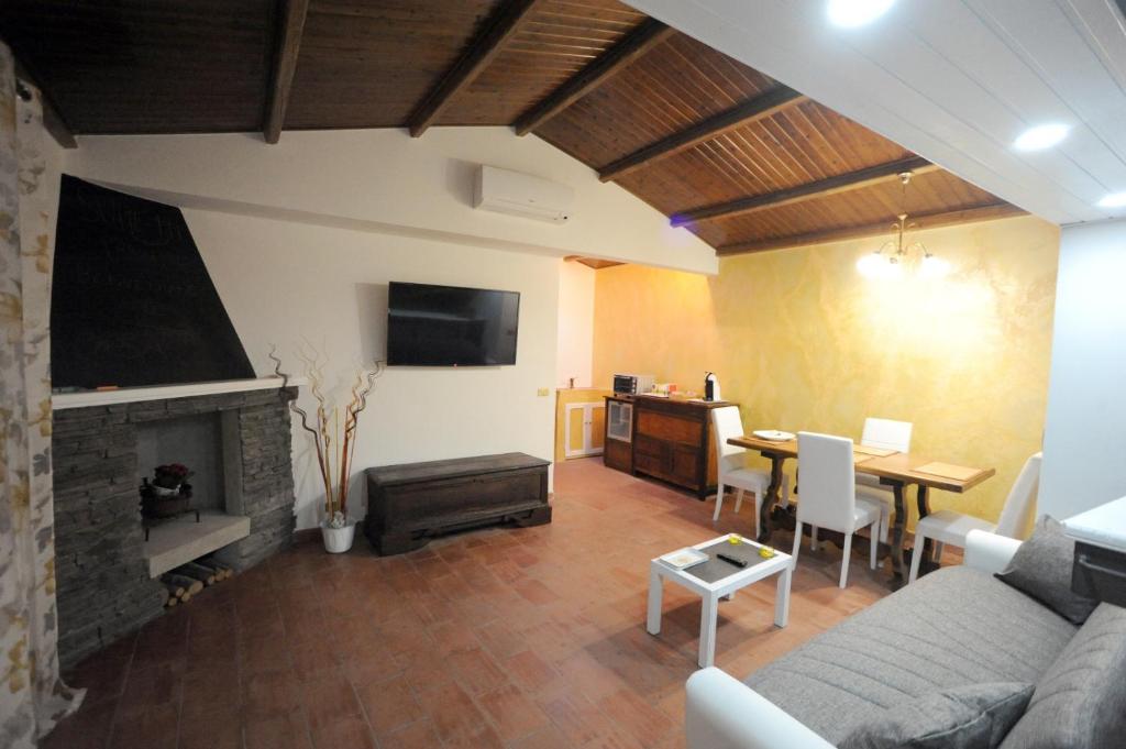 uma sala de estar com um sofá, uma mesa e uma lareira em SUITE-TTI em Valentano