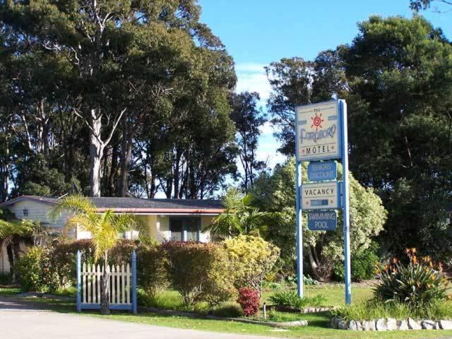 a sign for a motel in front of a house at Motel Farnboro in Narooma