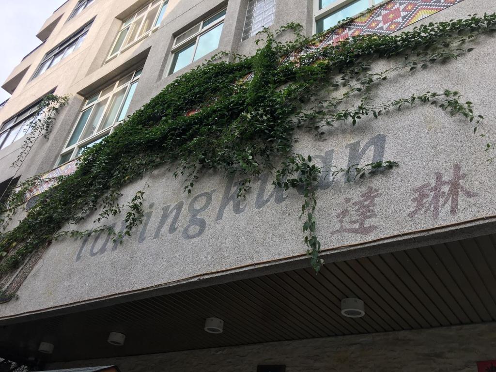 una señal en el lado de un edificio con plantas en Da Lin Gu Wan Homestay en Yuchi